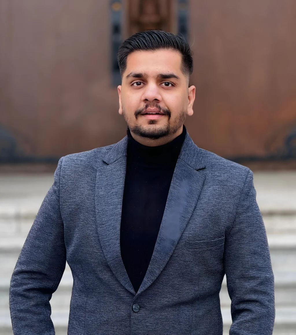 Addy, founder of LOCUSOLVE, in a grey blazer and black turtleneck.